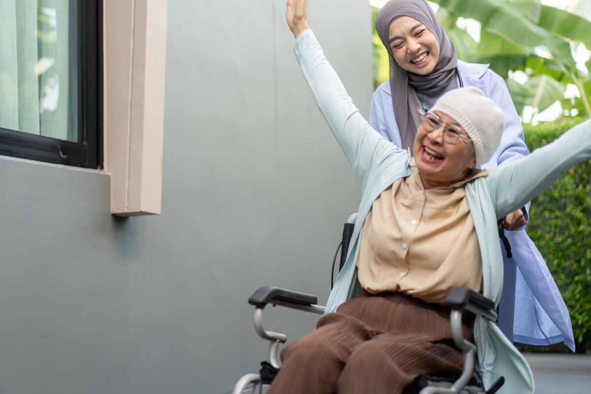 アジア人女性が車いすを押している