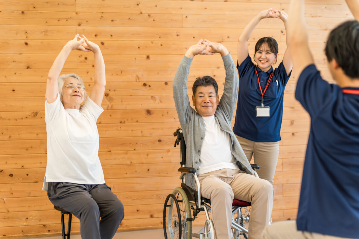 介護施設でストレッチをする利用者とリハビリスタッフ